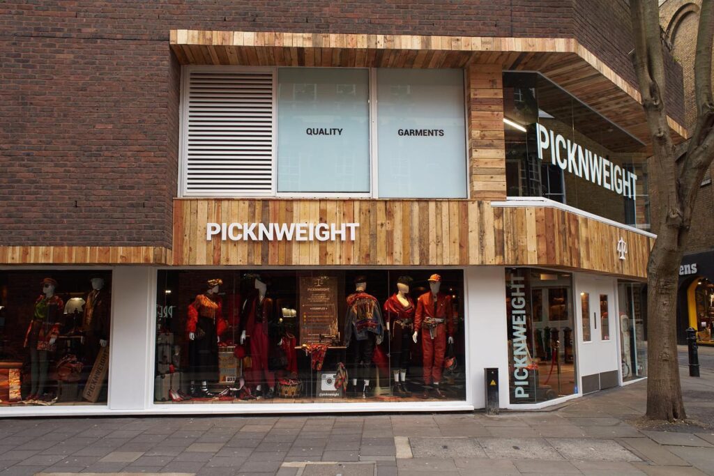 Außenansicht des PicknWeight thrift shop Berlin mit Schaufenstern voller Vintage-Mode.